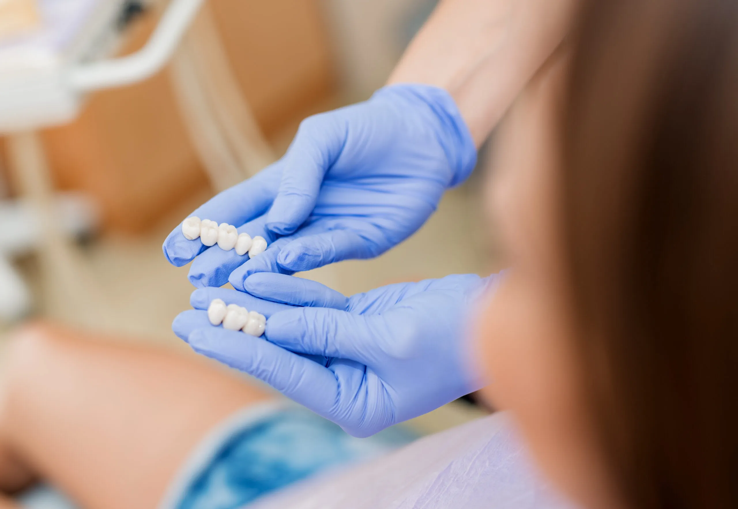 Dentist showing porcelain crowns to the patient. Close-up