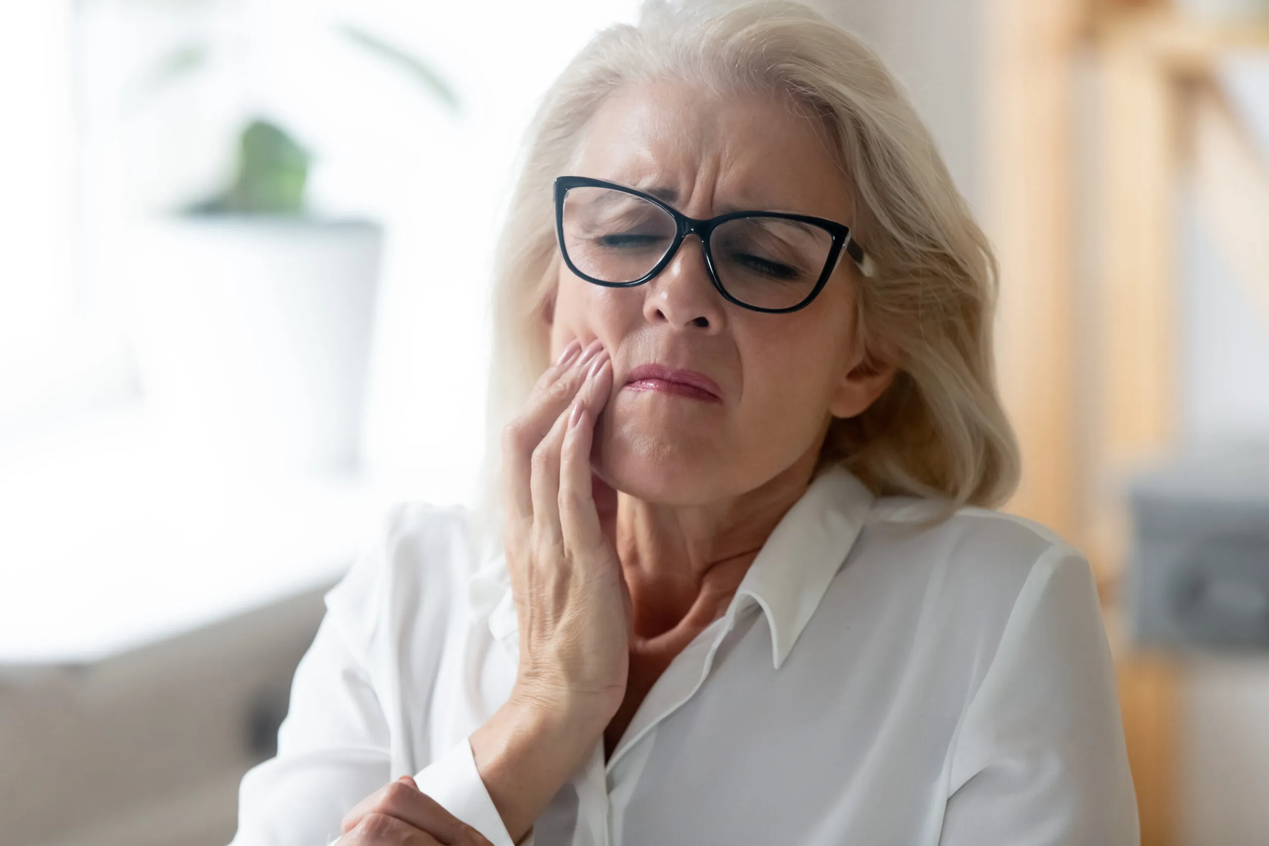 older woman suffering from tooth infection pain, tooth abscess